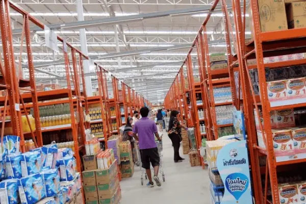 Interior view of Super Cheap Phuket with shelves full of goods, customers and typical market noise in a huge warehouse.