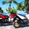 Drei Motorräder in unterschiedlichen Ausrichtungen, die ihre einzigartigen Designs und Funktionen für die Motorroller-Miete präsentieren.