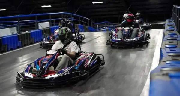 Racer wearing helmet driving a go-kart indoors in Phuket.
