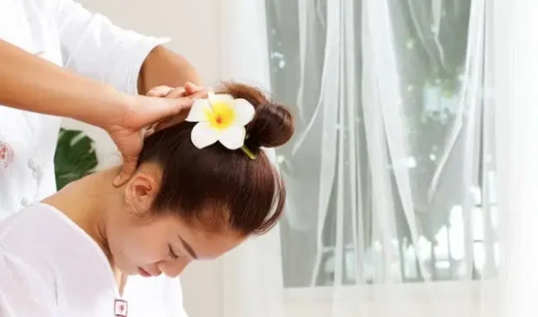 Woman receiving relaxing Thai massage with herbal oil in a Phuket spa.