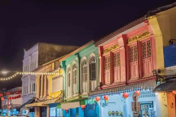 Colorful colonial buildings in Phuket Old Town with wet streets after rain.